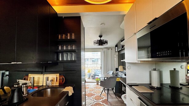 A modern kitchen with dark cabinetry, stainless steel appliances, and a central island. - New Listing. A short walk to the beach. (Provincetown)