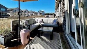A patio with a sofa, a table, an umbrella, and planters. - New Listing. A short walk to the beach. (Provincetown)