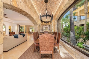 A dining area with a stone arch, a chandelier, and a view of the outdoors. - Hacienda Beach Club Villa w/ Private Pool! (Hacienda Beach Club & Residences)