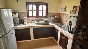 Una cocina con una isla central, estufa, fregadero y refrigerador.