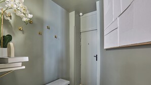 A bathroom with a bench, a toilet, and a shower area. - Superb Duplex in the Center of Paris (Paris)