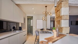 A modern kitchen with a central island, a built-in oven, and a pendant light. - Superb Duplex in the Center of Paris (Paris)