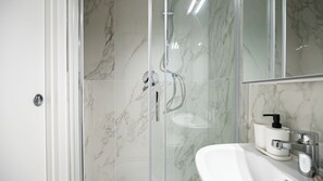 A modern bathroom with a glass-enclosed shower, a white sink, and a marble-tiled wall. - Italianway Easy - The B Village Basic Apt AT02 (Milano)