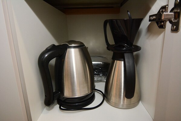 A kitchen with a kettle and a coffee maker.