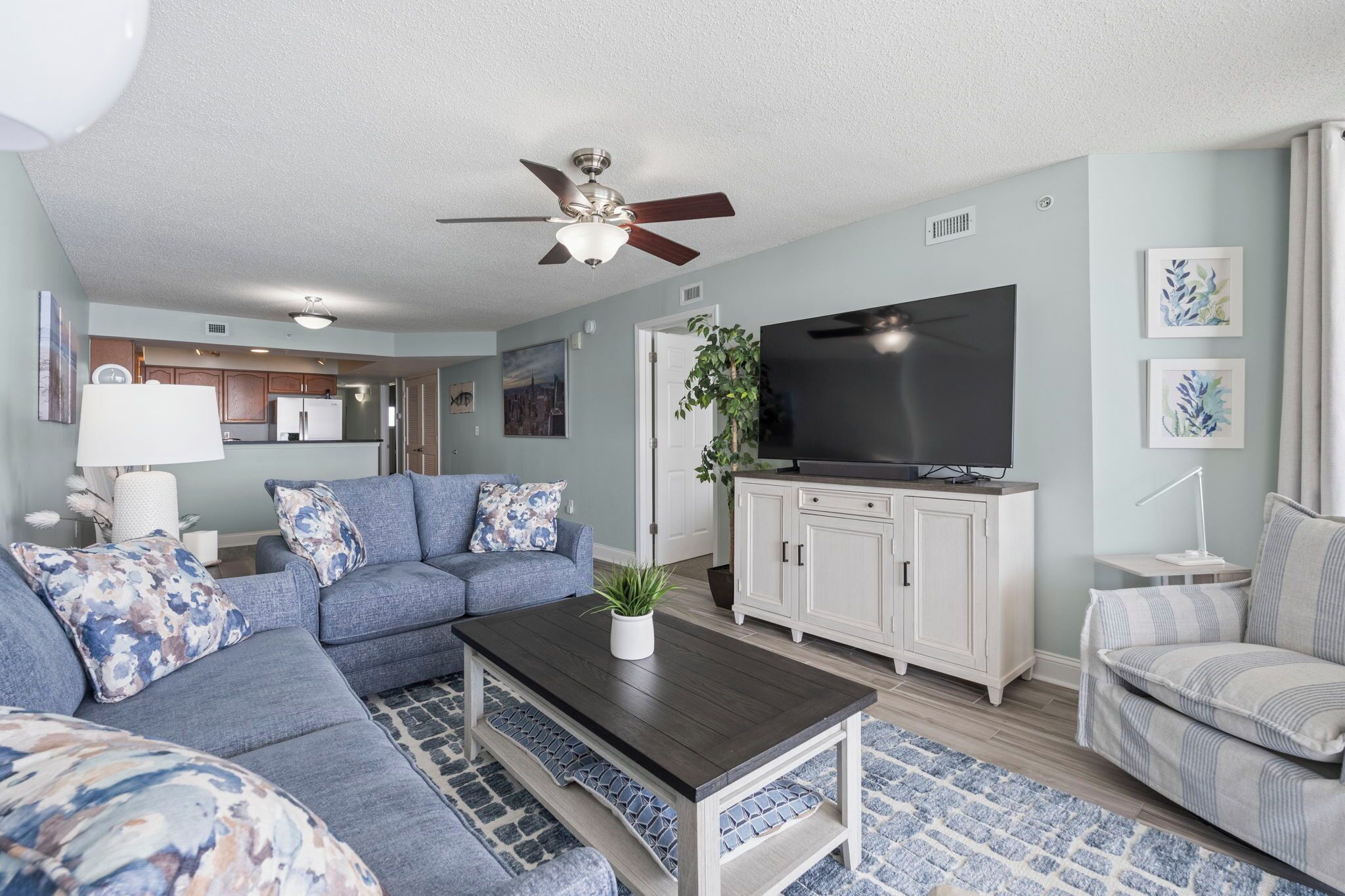 A living room with a sofa, coffee table, TV, and cabinets.