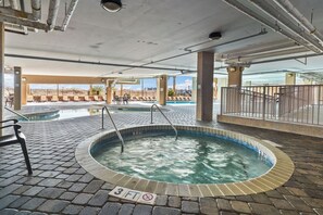 Ein Poolbereich mit Whirlpool, Liegestühlen und einem Sprungverbot-Schild.