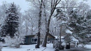 Ein Haus, umgeben von schneegebundenen Bäumen.