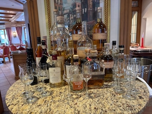 A bar area with various bottles and glasses on a granite countertop. - Room 11 Standard Double Room with Wi-Fi (Seefeld)
