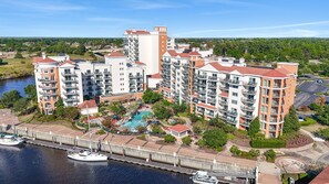 Un hôtel de grande hauteur doté de nombreux balcons, d’une piscine et d’un port de plaisance.