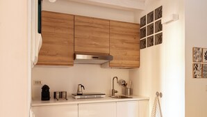 Una cucina con mobili in legno, un piano di lavoro bianco, un lavello e un'area pranzo con tavolo apparecchiato per due.