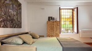Una camera da letto con un letto, un armadio, una finestra vista e un condizionatore d'aria.