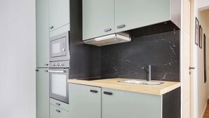 A kitchen with a built-in oven, a sink, and cabinets. - Charming Studio for 2P - Near Parc Monceau (Paris)