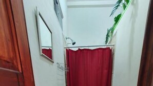A compact bathroom with a white sink, toilet, and red shower curtain. - Zacatecoluca House (Zacatecoluca)