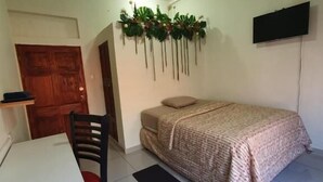 A bedroom with a bed, a desk, a chair, a ceiling fan, and a TV. - Zacatecoluca House (Zacatecoluca)