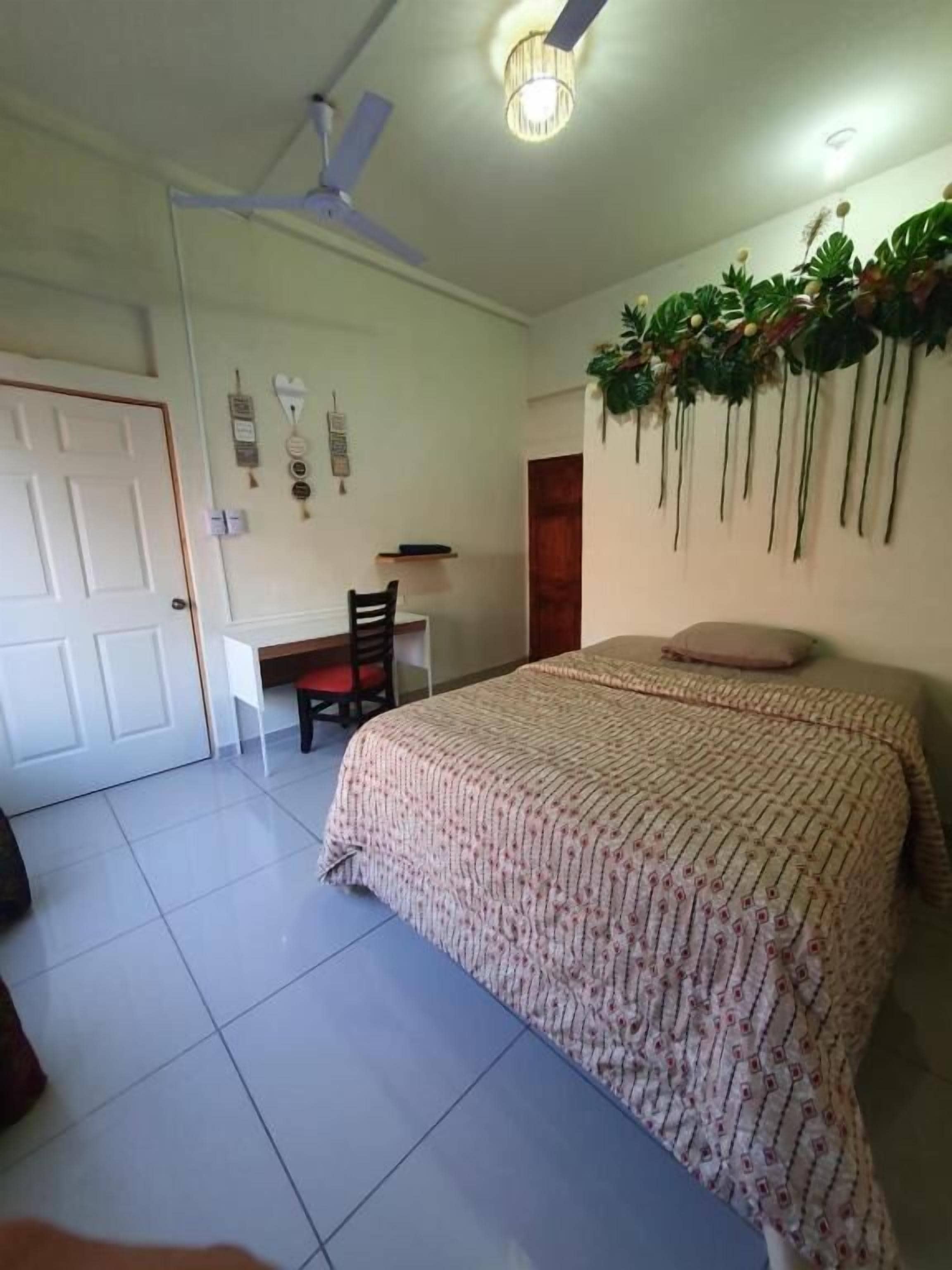 A bedroom with a bed, a desk, and a chair.