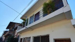 A two-story residential building with a balcony, barred windows, and a gated entrance. - Zacatecoluca House (Zacatecoluca)