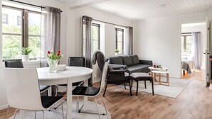 Un grand espace de vie comprenant une table à manger, des chaises, un canapé et une petite table basse.