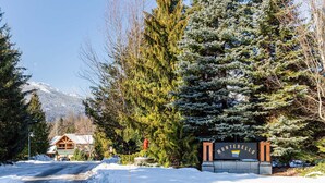A lodge with a snow-covered driveway, a fire hydrant, and a sign with the name 'Montebello.' - Harmony Chalet at Montebello (Whistler)