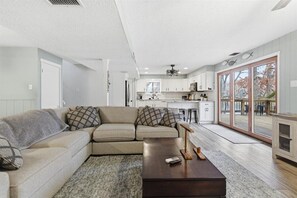 Ein modernes Wohnzimmer mit einer Eckcouch, einem Couchtisch und einer Küche im Hintergrund.