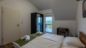 A bedroom with two beds, a balcony, and a chair. - Amazing home in Banfi (Banfi)