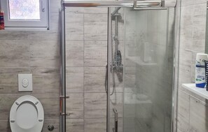 A bathroom with a glass-enclosed shower, a toilet, and a sink with a soap dispenser. - Beautiful home in Slavonski brod (Slavonski brod)