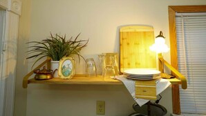 Ein Regal mit einem Blumentopf, einem gerahmten Bild und einer Lampe.