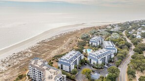 Un hôtel situé sur la côte, composé de plusieurs bâtiments, avec une plage et un parking.