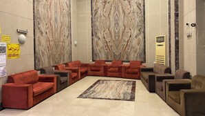A lobby with a marble wall, seating area, and a reception desk. - nazal alroh alhora -Hajj Street (Makkah)