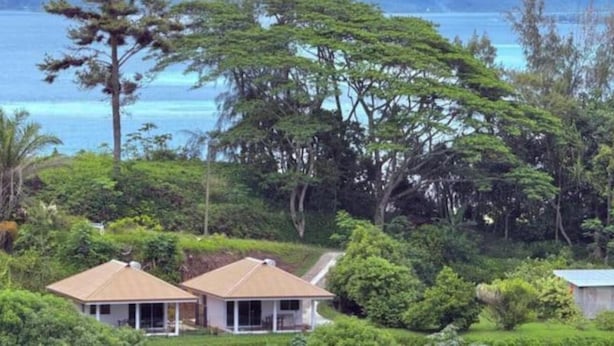 A house surrounded by dense greenery and a view of the ocean. - Bungalow Hoarai Uturoa (Uturoa)