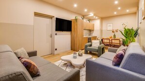 A modern living room with a sofa, coffee table, and a dining area with chairs and a table. - Spacious Apartment - 2br/10p - Place D'italie (Paris)