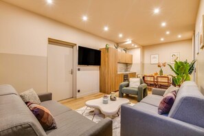 Ein modernes Wohnzimmer mit einer Couch, einem Couchtisch und einem Essbereich mit Stühlen und einem Tisch.