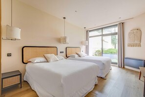 Ein Hotelzimmer mit zwei Betten, einem großen Fenster und einem Wandradiator.
