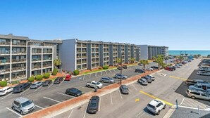 Ein mehrstöckiges Hotel mit Parkplatz und Blick auf den Ozean.