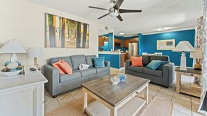 Ein Wohnzimmer mit zwei Sofas, einem Couchtisch und einem Deckenventilator.