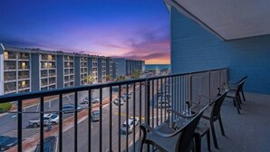 Ein Balkon mit Blick auf einen Parkplatz und ein Gebäude gegenüber.