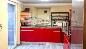 A kitchen with red cabinets, a marble backsplash, and a stainless steel refrigerator. - Holiday Home in Konz (Konz)