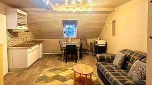A compact living space with a kitchen, dining area, and a sofa. - Gemütliche Wohnung in Konz an der Mosel (Konz)