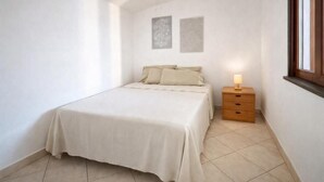 Un dormitorio con cama, mesita de noche y decoración en la pared.