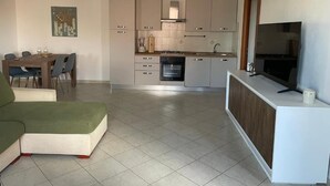 Una cocina moderna con comedor, televisor y un cuadro en la pared.