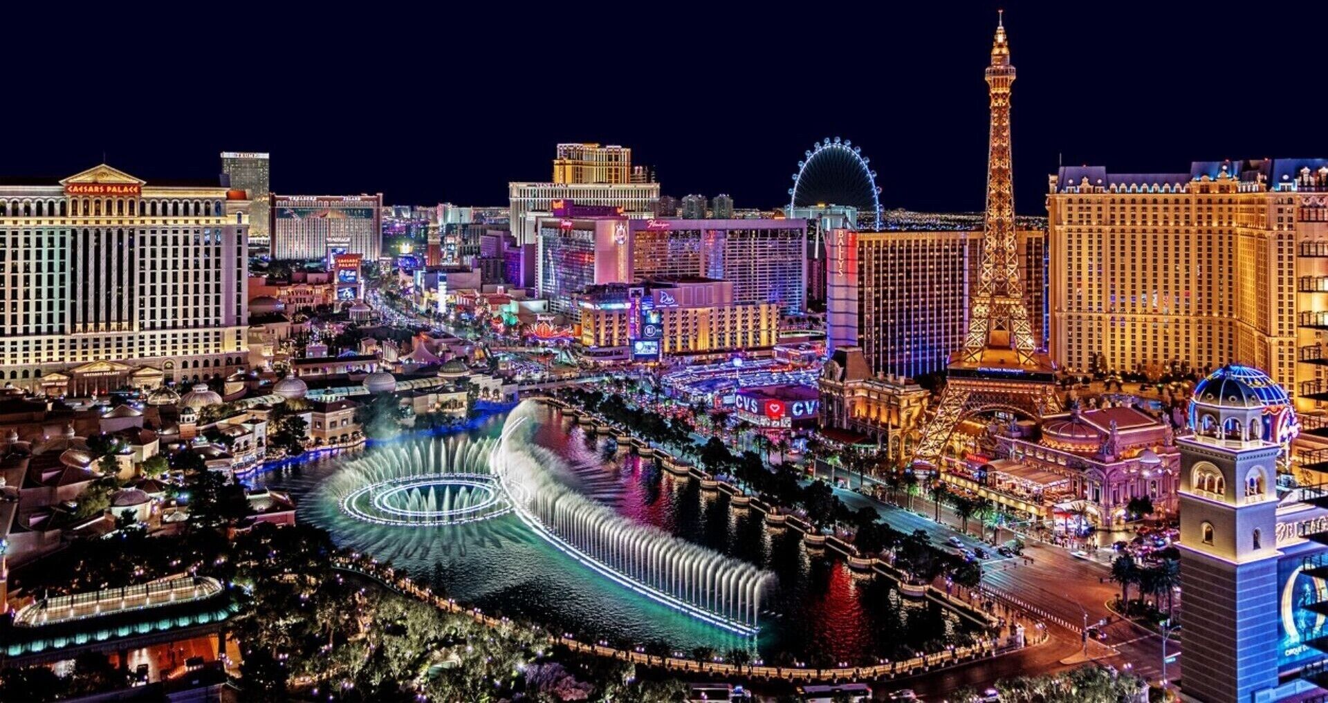 Bybillede med markante bygninger som Caesars Palace og et stort pariserhjul.