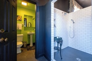 A bathroom with a toilet, sink, and shower area.
