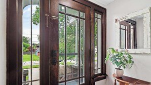 Eine Holztür mit Glasfeldern, ein Blumentopf und ein kleiner Holztisch.
