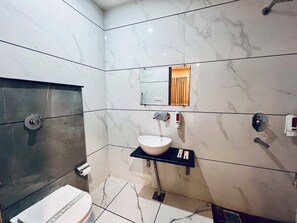 A modern bathroom with a toilet, sink, and shower. - THE KING HAWK Nearby GOLDEN TEMPLE (Amritsar)