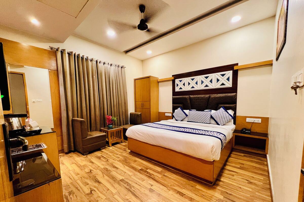 Un dormitorio con cama, escritorio, silla, armario y ventilador de techo.