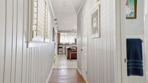 A hallway with wooden flooring, white walls, and a blue towel hanging on a door. - Right at Home-Midland Home away from Home with Billiards (Midland)