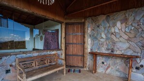 Un intérieur rustique avec un mur en pierre, un banc en bois et une porte.
