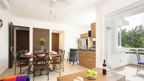 Un apartament modern amb zona de menjador, cuina i balcó amb vistes.