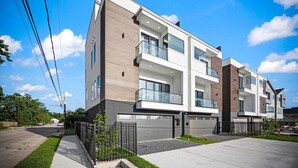 Een modern appartementencomplex met balkons, grote ramen en een verzorgd gazon.