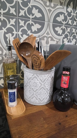 A kitchen counter with a utensil holder, a bottle of Star Red Wine Vinegar, a bottle of olive oil, and a wooden cutting board. - Angella Ct Getaway - Sleeps 6 - Near Downtown (McMinnville)