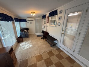 A hallway with a bench, a door with a screen, and a ceiling light fixture. - Gilbert Get Away with private dock, boat ramp and gorgeous views (Gilbert)